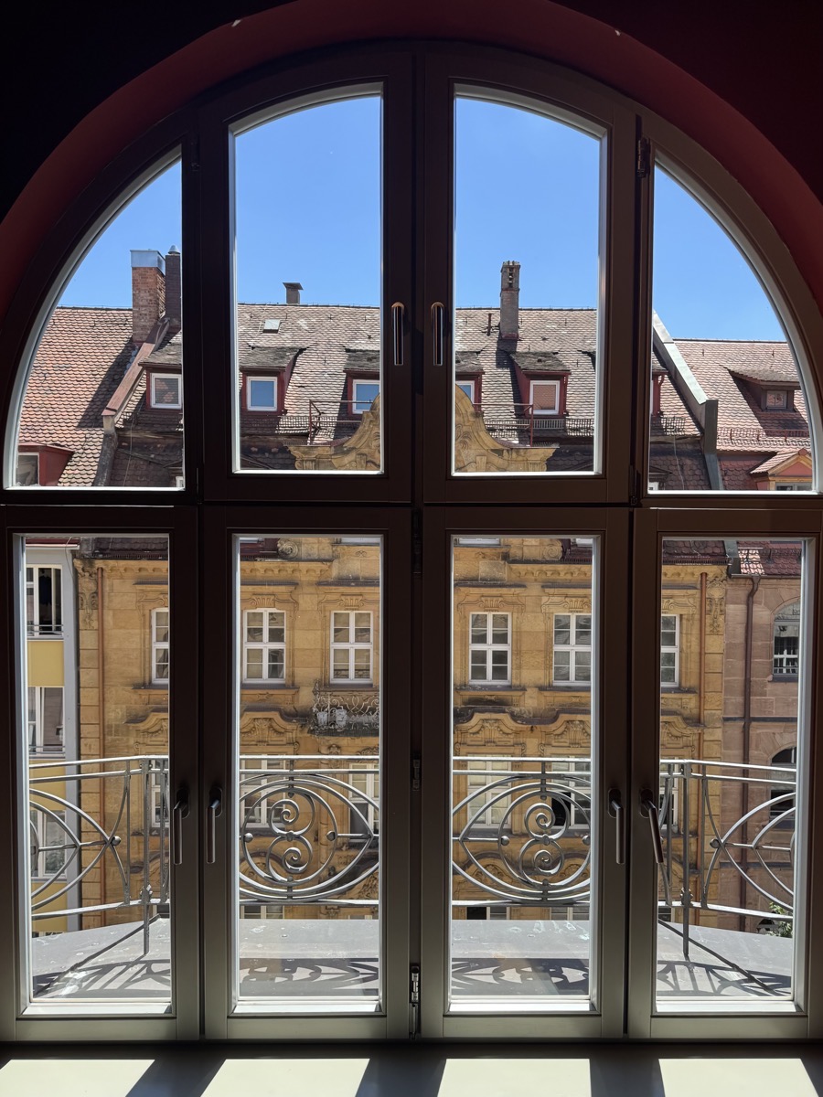 Gereinigtes Rundbogenfenster mit Balkon